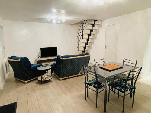 un salon avec une table et des chaises et un escalier dans l'établissement Maison centre ville, à Calais