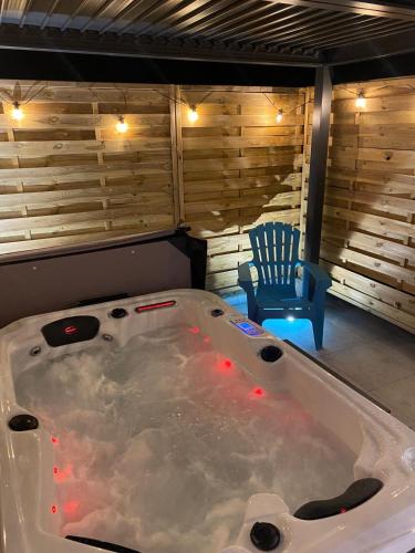 a large bath tub in a room with a blue chair at Relax et spa caché in Lagny