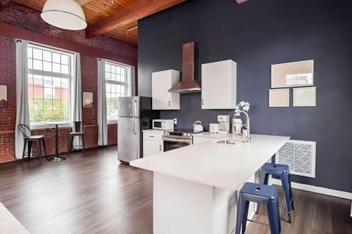 a kitchen with a white counter and a refrigerator at Jennifer's Riverfront Loft Apartment Historic Building in Providence