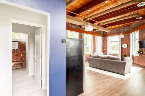 a living room with a couch and a room with a wall at Jennifer's Riverfront Loft Apartment Historic Building in Providence