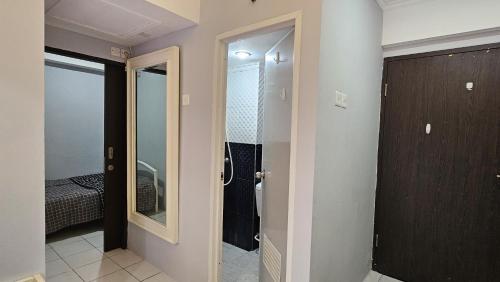 バンドンにあるJarrdin apartment Cihampelas 2BR pool view by Nemui Roomのウォークインシャワーと鏡付きのバスルーム