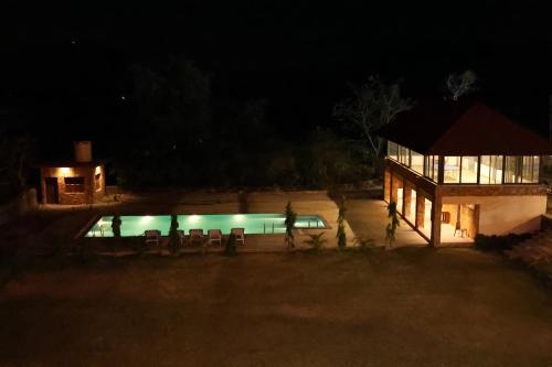 a house with a swimming pool at night at Jai Niwas Palace Resort in Kumbhalgarh