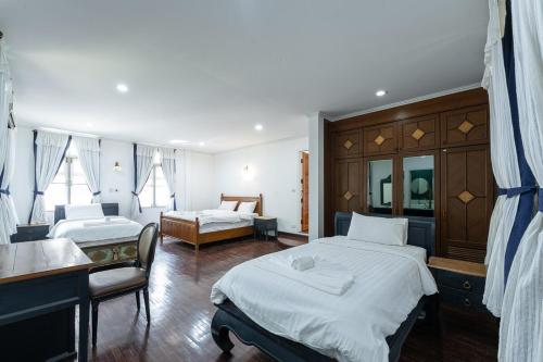 a hotel room with two beds and a sink at Baan Nai Chiang Mai Retreat House Private Pool in Chiang Mai