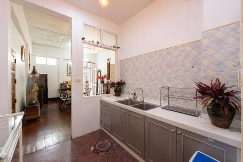 a kitchen with a sink and a mirror at Baan Nai Chiang Mai Retreat House Private Pool in Chiang Mai