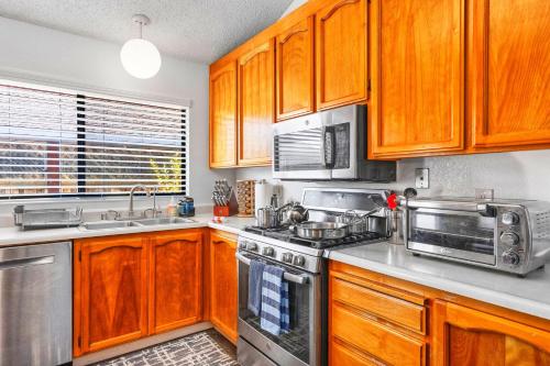 a kitchen with wooden cabinets and stainless steel appliances at Wine Country King Bed BBQ Stocked in Santa Rosa