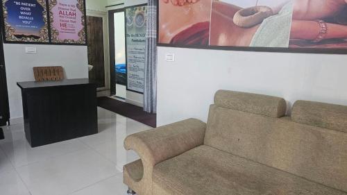 a living room with a couch and a picture on the wall at Arogya Mandir Ayurvedic Home Stay in Belgaum