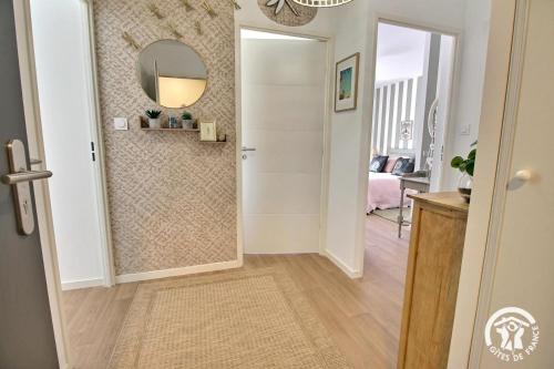 a hallway with a door and a mirror on a wall at Le clos du ponant in Ploeren