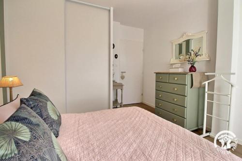 a bedroom with a bed and a dresser and a mirror at Le clos du ponant in Ploeren