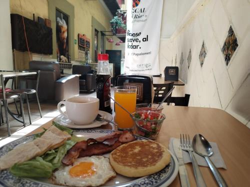een bord ontbijtproducten met eieren, spek en toast bij Aroma Hotel in Puebla