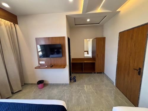 a room with a bed and a tv and a mirror at Hotel Sisodiya Palace in Khātu