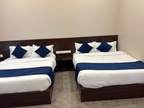 two beds in a room with blue and white pillows at Hotel Sisodiya Palace in Khātu