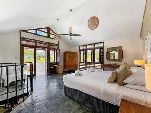 a bedroom with a large bed and a balcony at Wongalinga Beachfront Apt 2 in Mission Beach