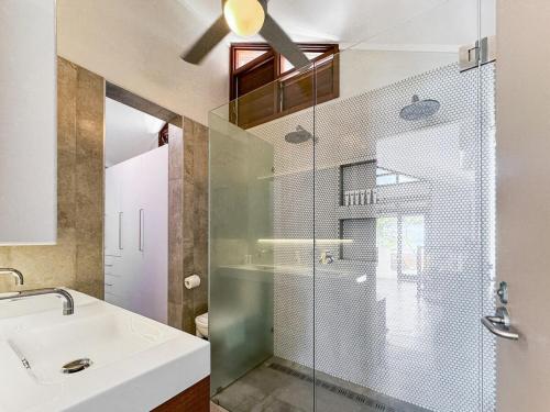 a bathroom with a glass shower and a sink at Wongalinga Beachfront Apt 2 in Mission Beach