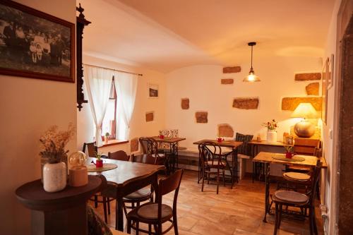 a dining room with tables and chairs and a kitchen at Penzion Štěrbova vila in Bílá Třemešná