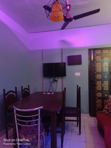 a dining room with a table and purple lighting at Ganges staycation in Nangi