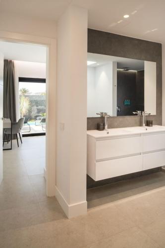 a white bathroom with a sink and a mirror at ODIN VILLAS by Buenavilla in Puerto Calero