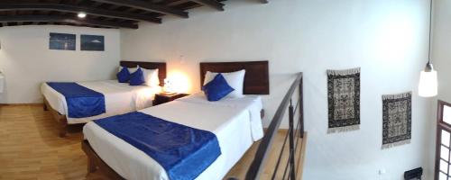 een slaapkamer met 2 bedden met blauwe en witte lakens bij Aroma Hotel in Puebla