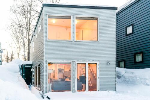 a house with sliding glass doors in the snow at Yamabiko in Niseko