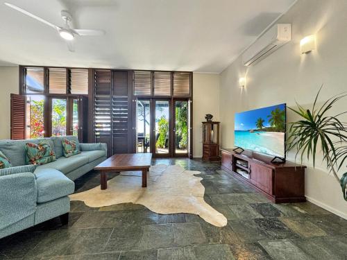 a living room with a couch and a flat screen tv at Wongalinga Beachfront Apt 6 in Mission Beach