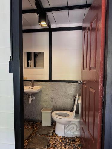 a bathroom with a toilet and a sink at Lantamangrove in Ban Ru Yai