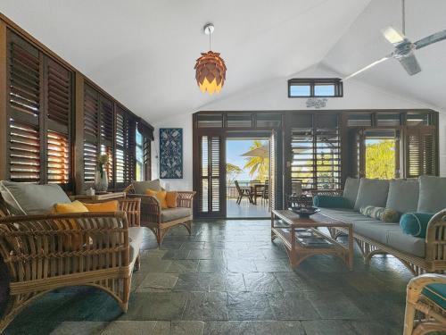a living room with couches and chairs and a table at Wongalinga Beachfront Apt 8 in Mission Beach