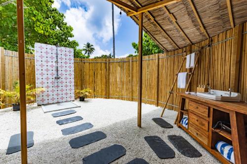 a patio with a wooden fence and a wooden table at The MAVERICK SURF AND DIVE BOUTIQUE HOTEL - Book 10 Nights and get 1 Free Night - Free Speed Boat Service - Kids Stay Free in Laamu