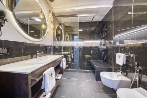 ein Badezimmer mit zwei Waschbecken und zwei Spiegeln in der Unterkunft City CENTRAL Apartment - Attico Porto Brenzone -lakefront rooftop terrace in Brenzone sul Garda