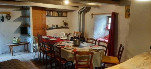 une salle à manger avec une table et des chaises et une cuisine dans l'établissement Le MàS du Plot, à Sablières