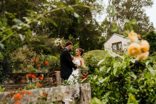 a bride and groom standing in a garden at The Rustic Nest Yarramalong in Yarramalong