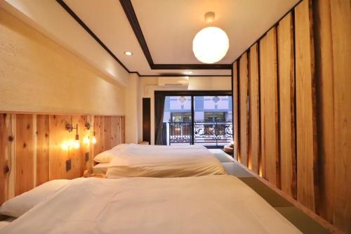a bedroom with two beds and a balcony at サンモールクレスト403 in Tokyo
