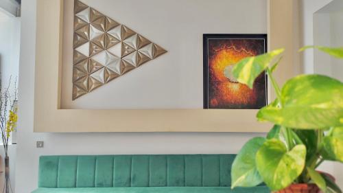 a picture hanging on a wall with a green couch at La Mansion Durian Hotel in Kampot