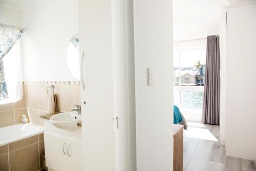 a bathroom with a sink and a mirror at 33 Kingston Place, Marina Martinique in Jeffreys Bay