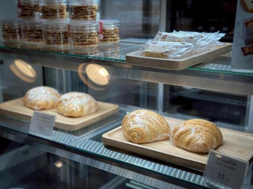 a bakery display case with loaves of bread on trays at Belivin'98 Sense of Pier Sathorn Residence in Bangkok