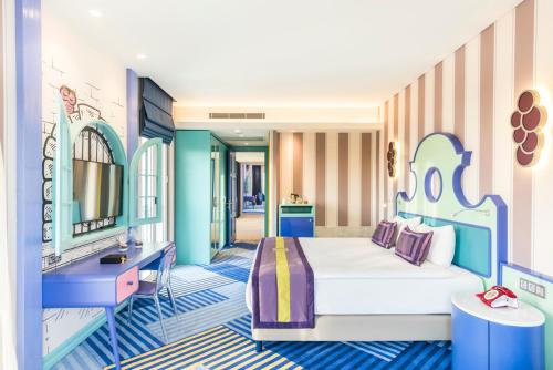a bedroom with a bed and a desk and a sink at The Land Of Legends Kingdom Hotel - All-in Concept in Belek