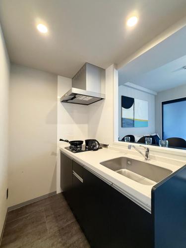 a kitchen with a sink and a stove at Lifement - 1min to Peace Park, Modern and Secure Apt in Hiroshima