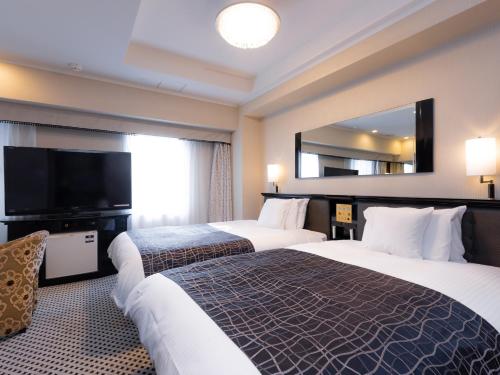 a hotel room with two beds and a large mirror at APA Hotel Asakusa Kuramae in Tokyo
