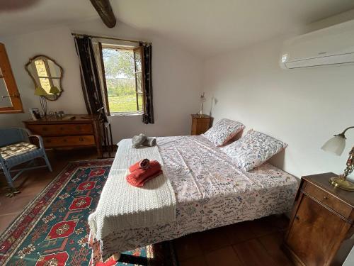 - une chambre avec un lit avec un animal farci rouge dans l'établissement La Méladière, à Mirabel-aux-Baronnies