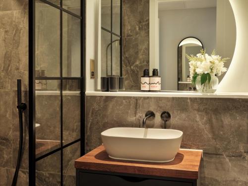 a bathroom with a white bowl sink on a wooden counter at Escapade Silverstone in Towcester
