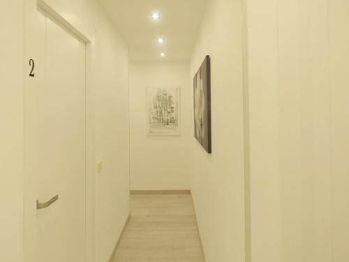 a hallway with two paintings on the wall and a hallway with a hallway at Pension Mayte in Pamplona