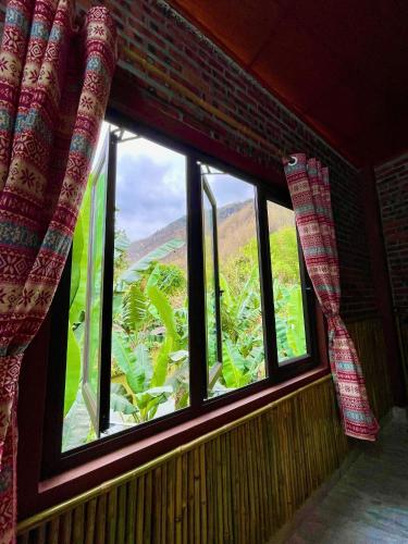 a window with curtains in a room with a view at Mai Chau Home Holiday in Mai Chau