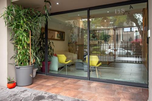 a store front with glass doors and potted plants at Capital O Hotel Terraza 158 in Mexico City