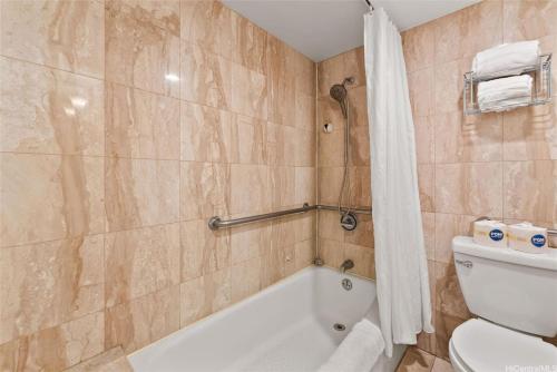 une salle de bain avec une baignoire, des toilettes et une douche dans l'établissement Aloha Seaside Vacations 4 Star Wyndham Resort 1803 Waikiki, à Honolulu