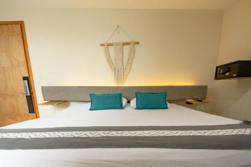 a bedroom with a large bed with blue pillows at Capital O Hotel Terraza 158 in Mexico City