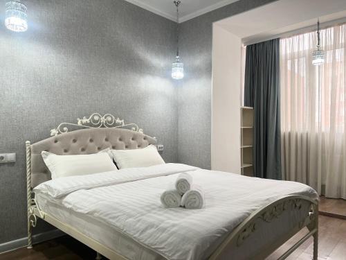 a bedroom with a bed with two towels on it at Двухкомнатные апартаменты LUX in Pavlodar