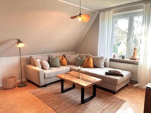 a living room with a couch and a coffee table at Sky & Sand - Endless Sea I Hochwertige, stilvolle Wohnungen, Strandnah, Boxspringbett, mit Garten in Sankt Peter-Ording