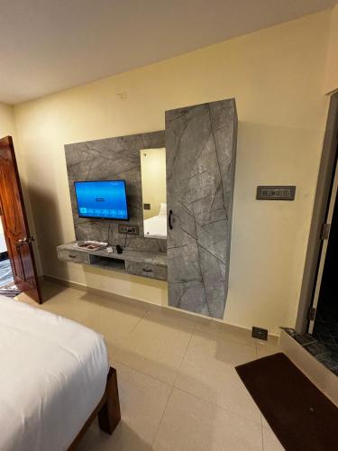 a bedroom with a large mirror and a tv on the wall at Royal Dreams Beach View in Puducherry
