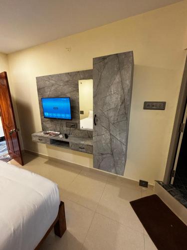 a bedroom with a large mirror and a television at Royal Dreams Beach View in Puducherry