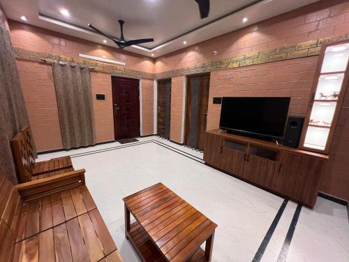 a living room with a flat screen tv and a couch at Temple Tales Homestay in Kumbakonam