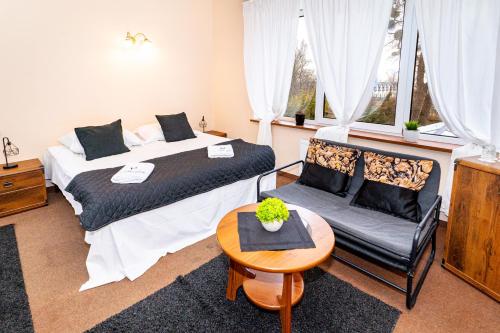 a bedroom with two beds and a table and a chair at Folwark Nadmorska Ostoja in Mechelinki