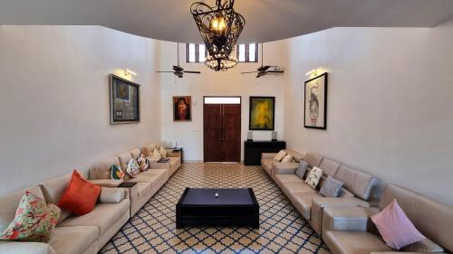 a large living room with couches and a chandelier at Casa Pallazzo Luxury Villa - 10BHK Private Pool in Baga